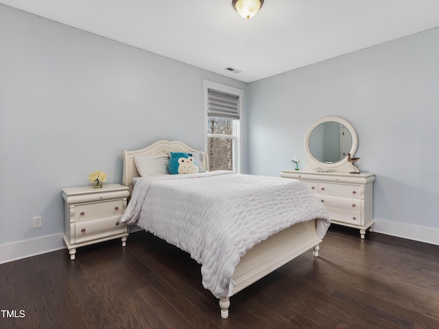 bedroom with visible vents, wood finished floors, and baseboards