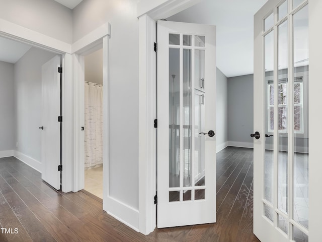 hall featuring dark wood-type flooring, french doors, and baseboards