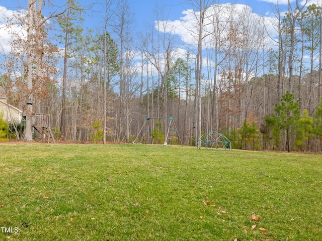 view of yard with a forest view and a playground