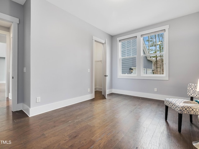 living area with baseboards and dark wood-style flooring