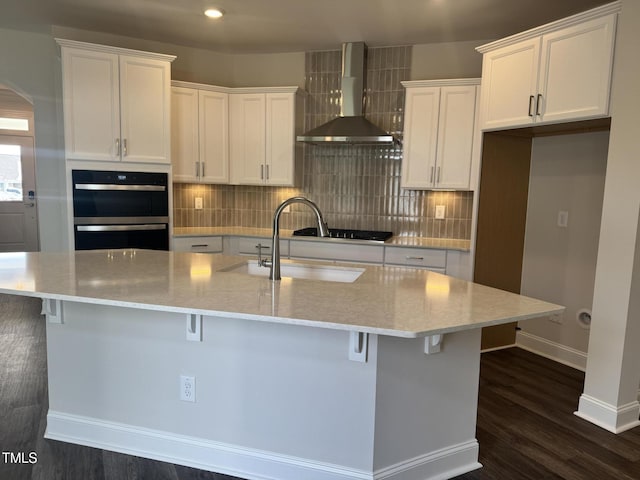 1315 Richfield Oaks Dr, Home, Fuquay Varina, NC 27526 - kitchen featuring white cabinetry, wall chimney exhaust hood, sink, and a kitchen island with sink