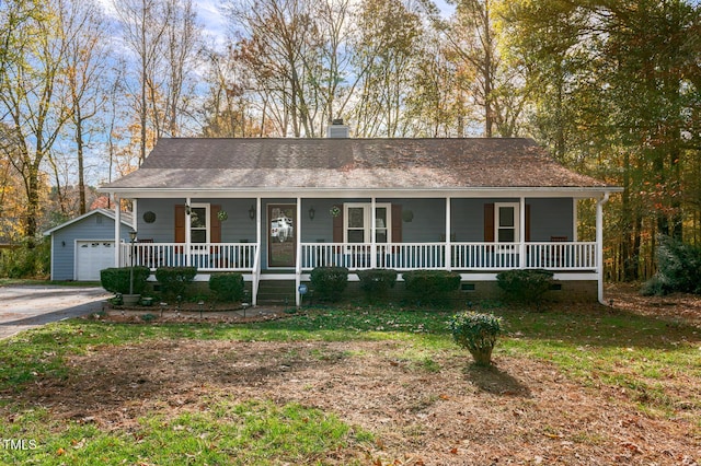 view of front of property with a garage, an outdoor structure, covered porch, and a front lawn