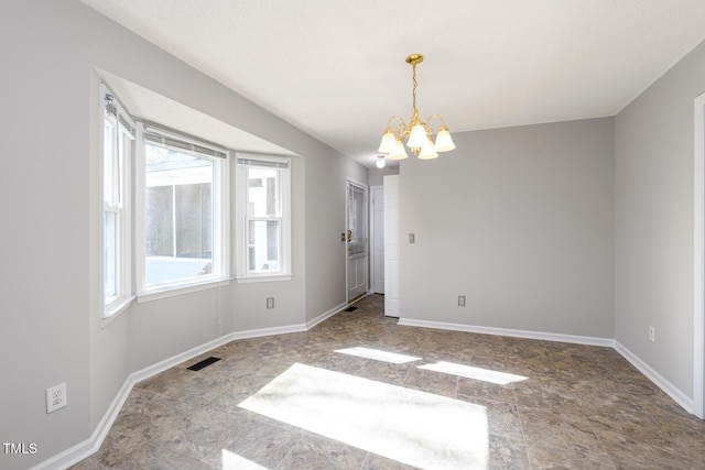 unfurnished room with a chandelier