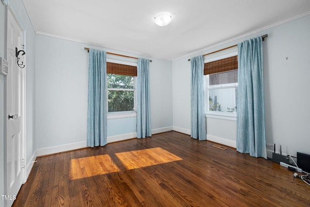 spare room featuring dark wood-type flooring and crown molding