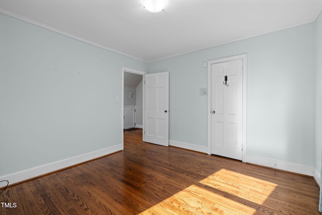 spare room featuring dark hardwood / wood-style flooring and crown molding