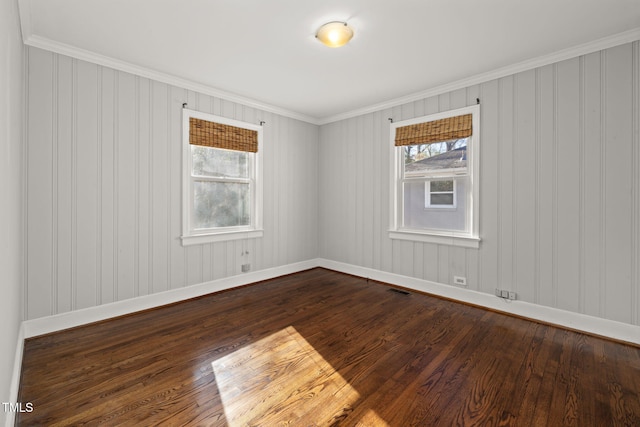 empty room featuring dark hardwood / wood-style flooring and ornamental molding