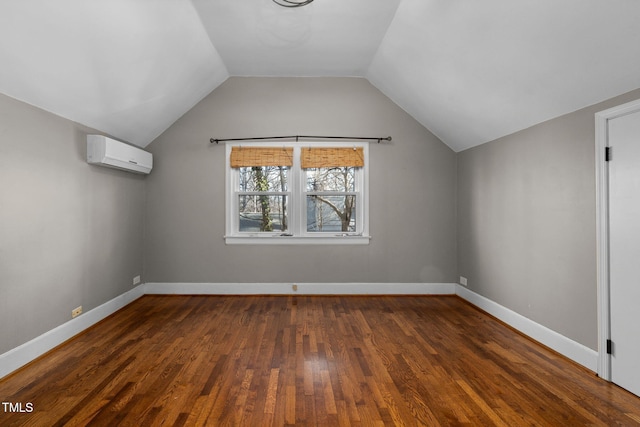 bonus room featuring vaulted ceiling, dark hardwood / wood-style floors, and a wall mounted AC