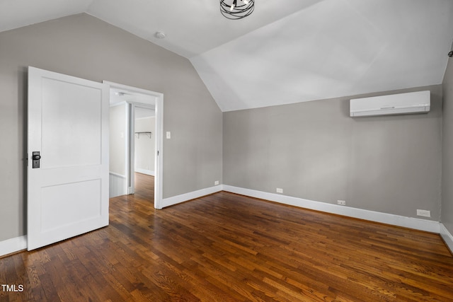 bonus room featuring vaulted ceiling, dark hardwood / wood-style floors, and a wall unit AC