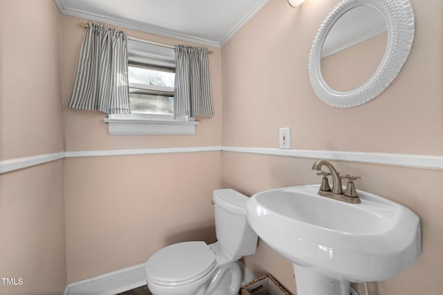 bathroom featuring crown molding, sink, and toilet