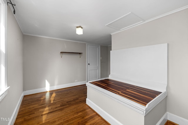 interior space featuring crown molding and dark wood-type flooring