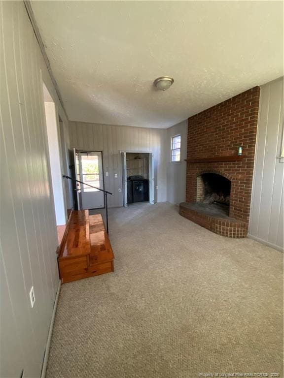 700 W 20th St W, Lumberton, NC 28358 - unfurnished living room with carpet flooring, a textured ceiling, a healthy amount of sunlight, and a fireplace