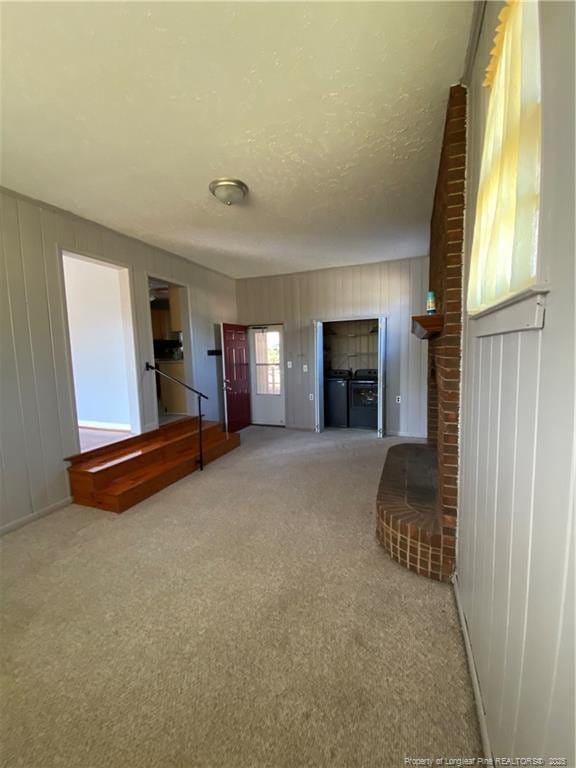 700 W 20th St W, Lumberton, NC 28358 - unfurnished living room with carpet flooring, washing machine and dryer, and a textured ceiling