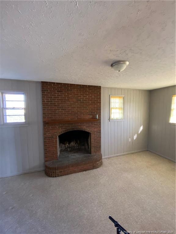 700 W 20th St W, Lumberton, NC 28358 - unfurnished living room featuring carpet floors, a textured ceiling, and a brick fireplace