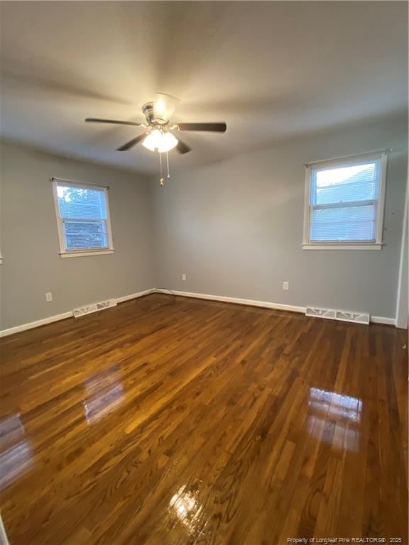 700 W 20th St W, Lumberton, NC 28358 - empty room with dark wood-type flooring, baseboards, visible vents, and ceiling fan