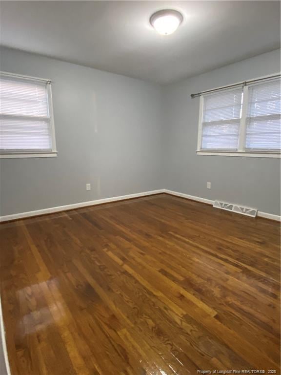 700 W 20th St W, Lumberton, NC 28358 - spare room featuring plenty of natural light, baseboards, visible vents, and dark wood-style flooring