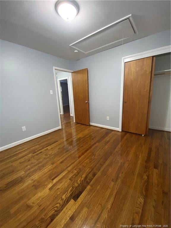 700 W 20th St W, Lumberton, NC 28358 - unfurnished bedroom featuring attic access, baseboards, and wood finished floors