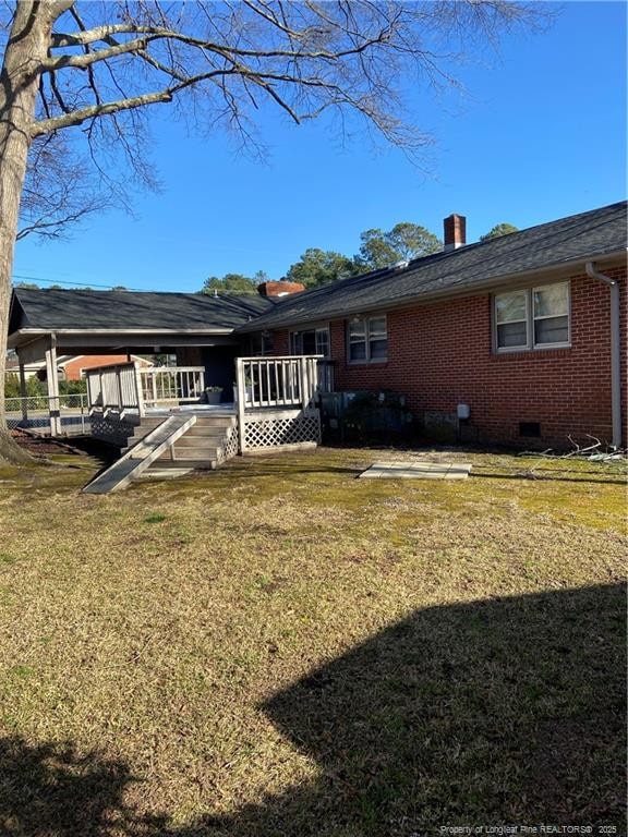700 W 20th St W, Lumberton, NC 28358 - rear view of house featuring brick siding, a wooden deck, a chimney, a yard, and crawl space