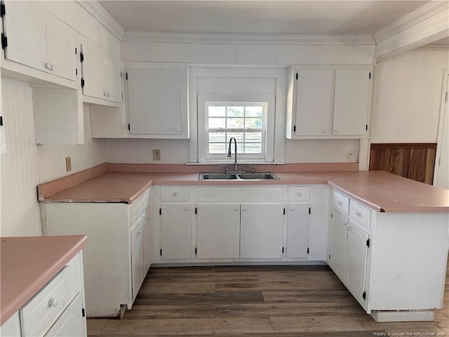 kitchen with dark hardwood / wood-style flooring, sink, crown molding, and white cabinets