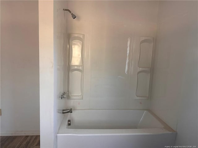 bathroom with bathtub / shower combination and hardwood / wood-style floors