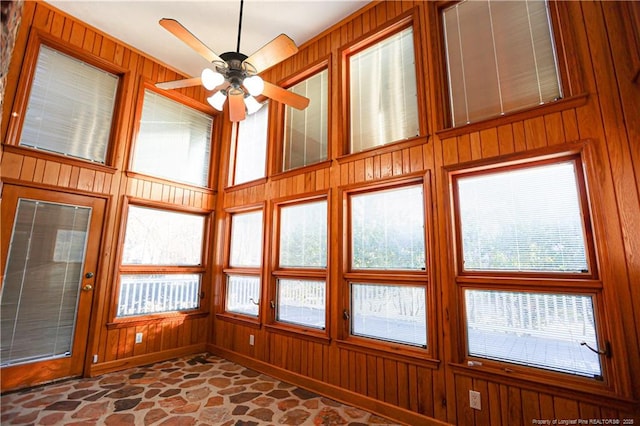 unfurnished sunroom with ceiling fan