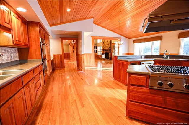 kitchen with pendant lighting, sink, wood ceiling, lofted ceiling, and stainless steel appliances