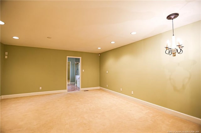 carpeted empty room featuring a notable chandelier