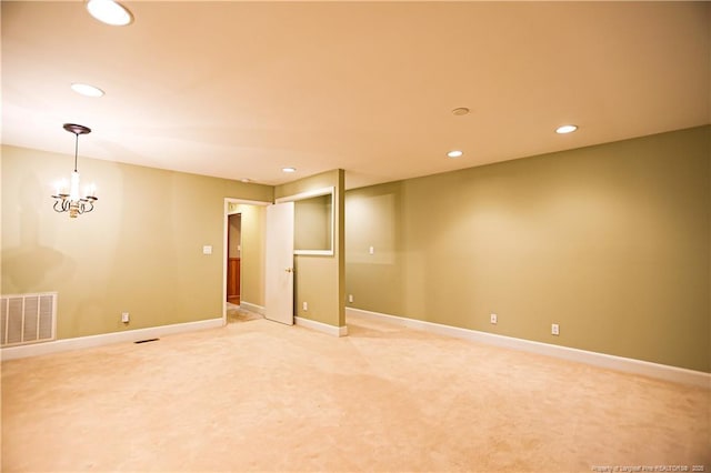 spare room with an inviting chandelier and carpet