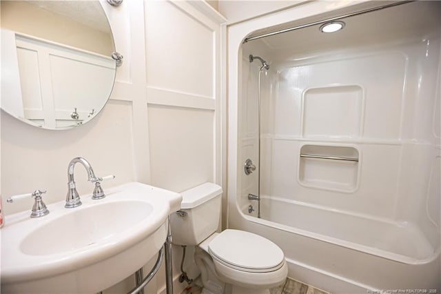 full bathroom with sink, bathtub / shower combination, and toilet