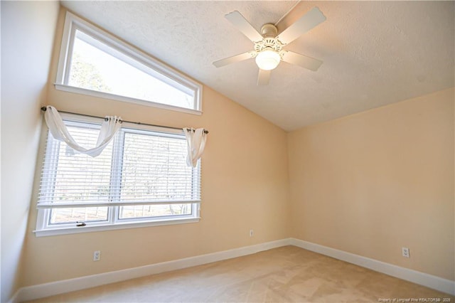 unfurnished room featuring vaulted ceiling, a wealth of natural light, ceiling fan, and a textured ceiling