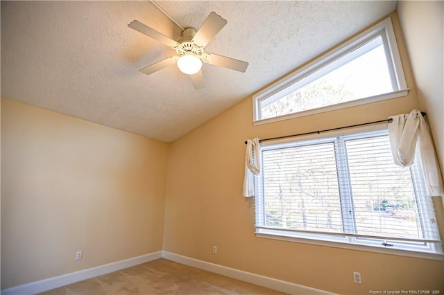 carpeted empty room featuring vaulted ceiling, ceiling fan, and a textured ceiling