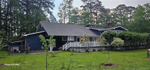 view of front facade featuring a wooden deck and a front yard