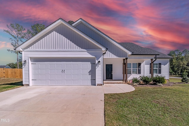 view of front of home with a garage and a yard