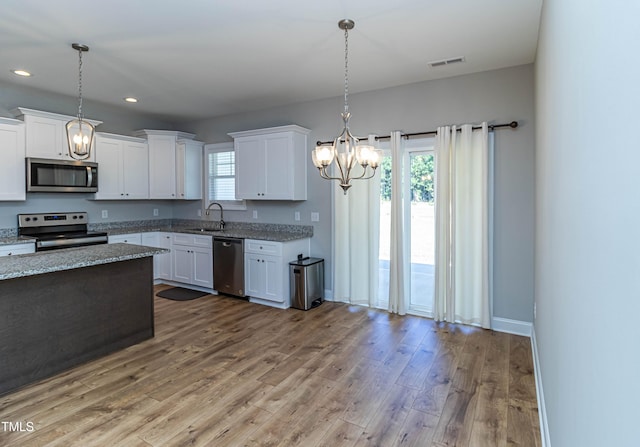 kitchen featuring white cabinetry, appliances with stainless steel finishes, sink, and pendant lighting