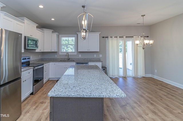 kitchen with stainless steel appliances, a kitchen island, and white cabinets