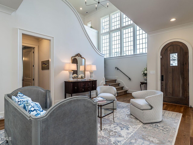 living room featuring hardwood / wood-style floors, a notable chandelier, a healthy amount of sunlight, and a high ceiling