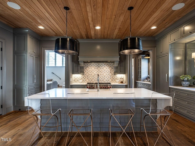 kitchen featuring wood ceiling, dark wood-style flooring, light countertops, gray cabinetry, and backsplash