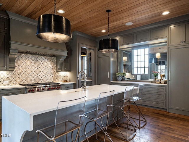 kitchen with dark wood-type flooring, gray cabinets, light countertops, and stove