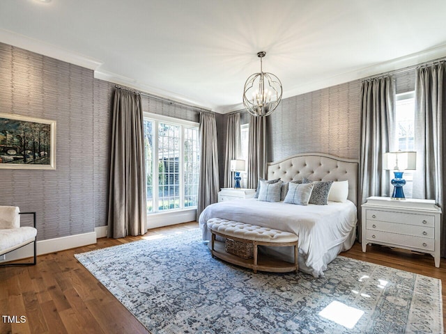 bedroom featuring ornamental molding, wood finished floors, a chandelier, baseboards, and wallpapered walls