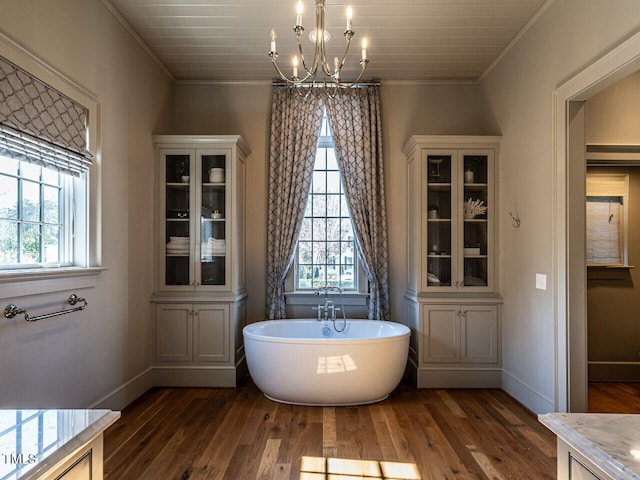 bathroom with crown molding, a bath, hardwood / wood-style floors, and a wealth of natural light