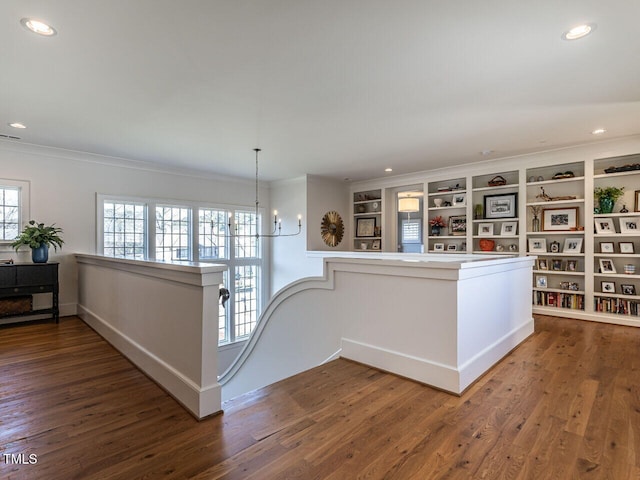 interior space with ornamental molding, wood finished floors, an inviting chandelier, an upstairs landing, and recessed lighting