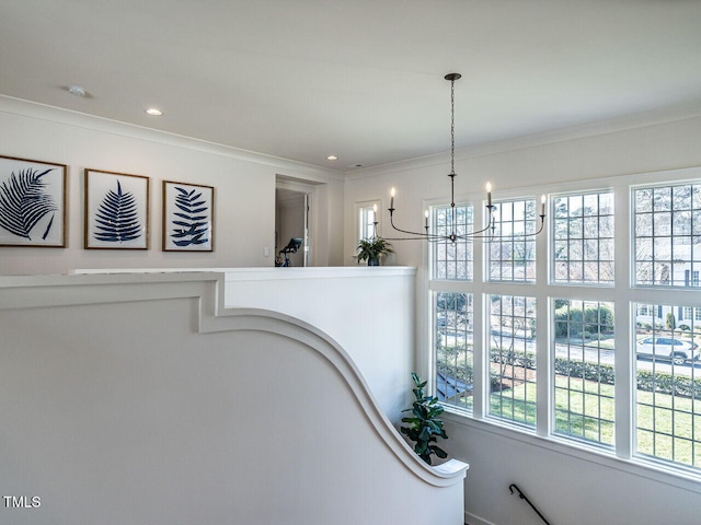 hallway featuring a notable chandelier and crown molding