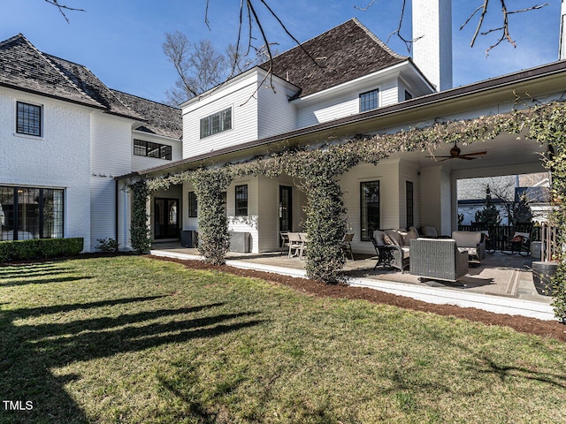 rear view of property featuring ceiling fan, a patio, a lawn, and an outdoor hangout area