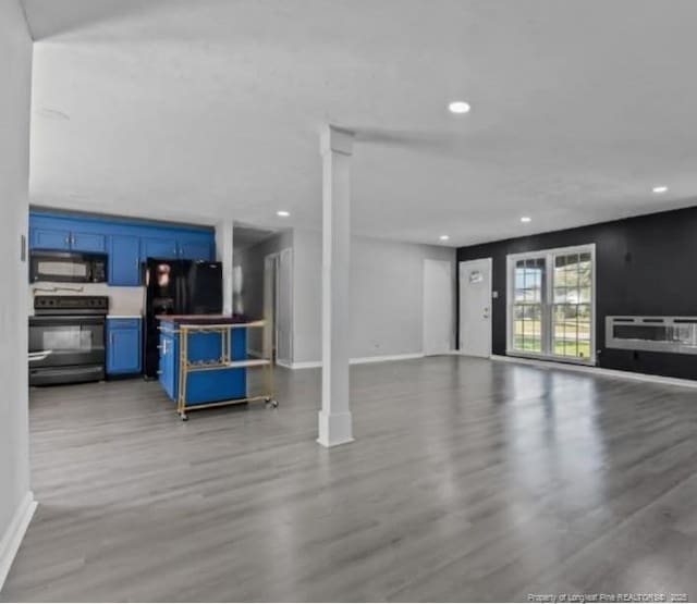 unfurnished living room with light hardwood / wood-style floors and ornate columns