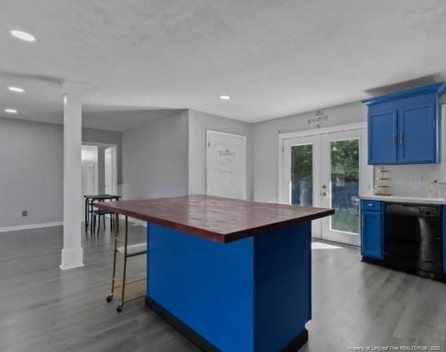 kitchen with french doors, blue cabinetry, a breakfast bar area, wooden counters, and dishwasher