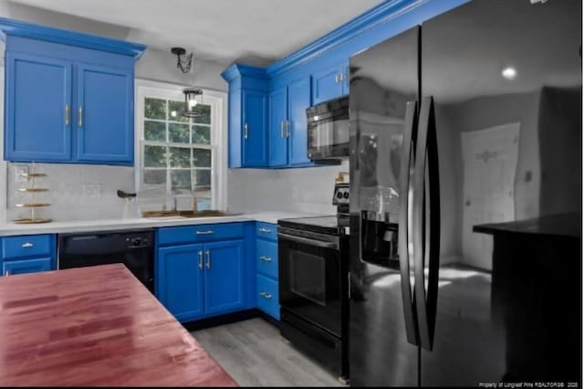 kitchen featuring black appliances, light hardwood / wood-style floors, and blue cabinetry