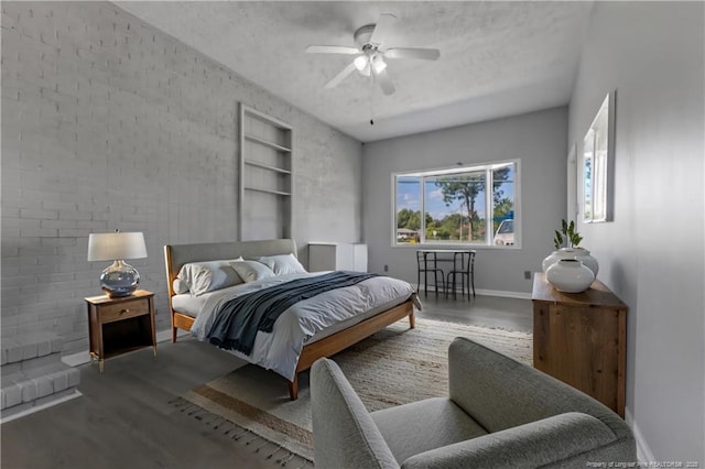 bedroom with ceiling fan, hardwood / wood-style floors, and a textured ceiling