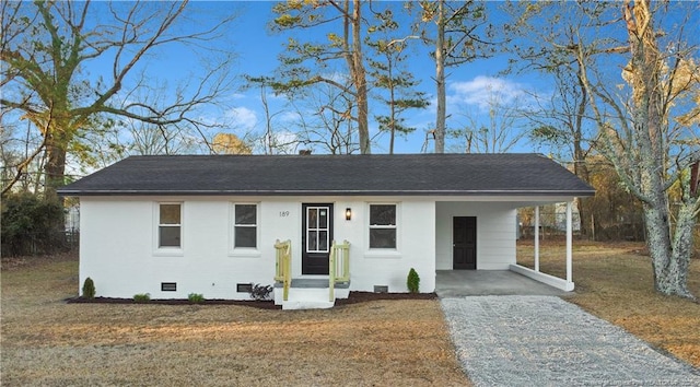 ranch-style house with a carport and a front lawn