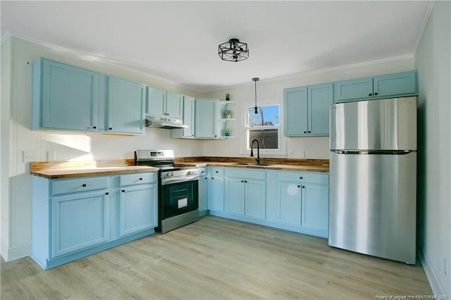 kitchen with appliances with stainless steel finishes, wood counters, decorative light fixtures, blue cabinets, and sink