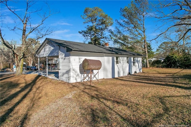 view of outdoor structure featuring a carport and a yard