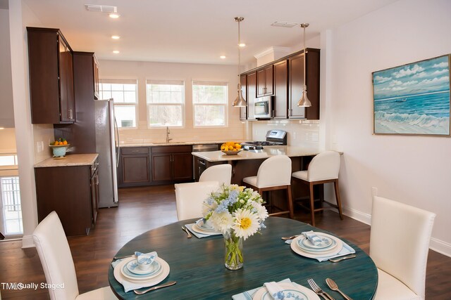 dining area with dark hardwood / wood-style flooring and sink